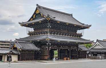 Fototapeta premium Beautiful view of the majestic temple Higashi Honganji in Kyoto, Japan. Very elaborate construction of wood and golden decorations on this temple. 