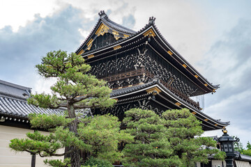 Low angle perspective on the majestic temple in Kyoto, Japan called Higashi Honganji.
Artistic view with surrounding trees.
