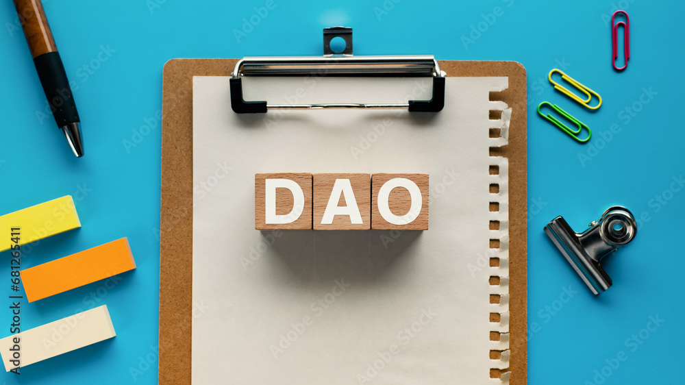 Poster there is wood cube with the word dao. it is an abbreviation for decentralized autonomous organizatio
