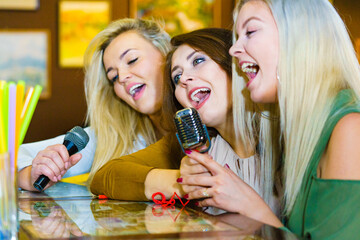 Women singing with microphone