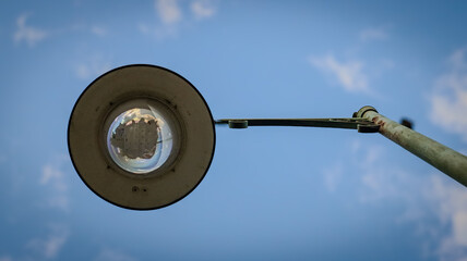 "Lamp post against a blue sky background."