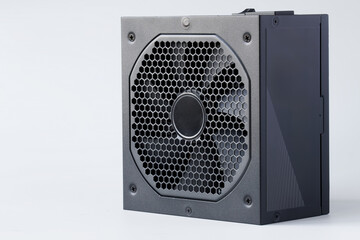 Fototapeta premium Modern computer AC power supply unit with a powerful fan on a white background. A device for power supply of a modern personal computer. Photo.