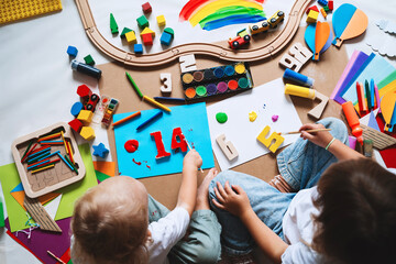 Children drawing and making crafts in kindergarten or daycare.