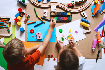 Children drawing and making crafts in kindergarten or daycare. - 681274236