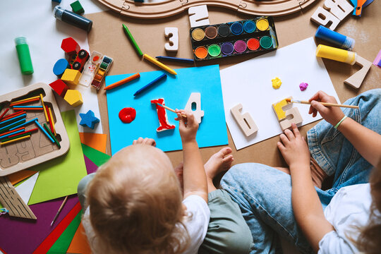 Children drawing and making crafts in kindergarten or daycare.