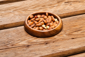 
Almond nuts in a wooden bowl on a rustic wooden table
