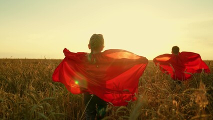 Children dreams of becoming superhero. Kids in red cloak, sun. Happy girl, boy play superheroes...