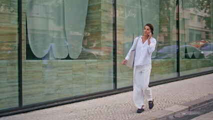 Elegant businesswoman talking mobile phone going to office. Woman ending call