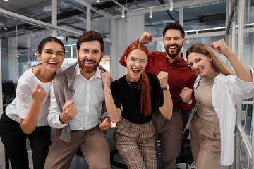 Team of employees celebrating success in office