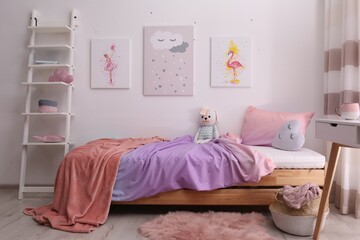 Comfortable bed with pink linens in children's room