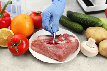 Scientist checking meat at table in laboratory, closeup. Quality control