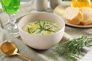 Delicious cream soup with tarragon, spices and potato in bowl on table