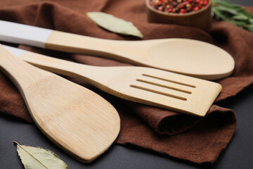 Set of wooden kitchen utensils on black table, closeup