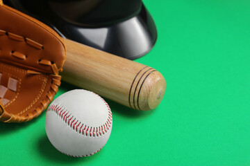 Baseball glove, bat and ball on green background, closeup. Space for text