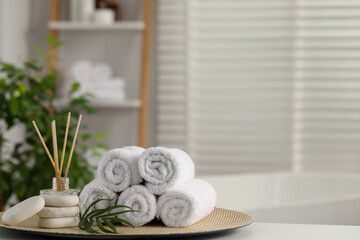 Obraz na płótnie Canvas Spa composition. Towels, reed diffuser, stones and palm leaves on white table in bathroom, space for text