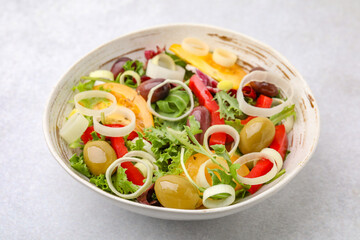 Bowl of tasty salad with leek and olives on light table