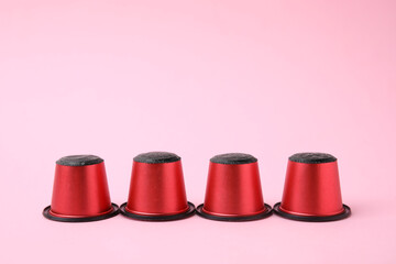 Many plastic coffee capsules on pink background