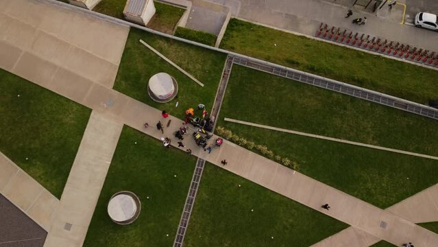 People stand on the path in the park, working in a movie, view from a drone