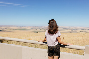 A young slender girl in short shorts and a nasty pink T-shirt with long dark hair walks among a beautiful recreation area. Scenic point view in Pendleton, Oregon, USA