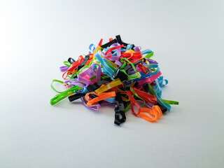 a pile of small colorful rubber hair ties or hair accessories isolated on white background.
