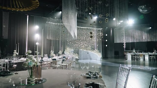 A very spacious and bright banquet hall is ready for the event. The camera captures a smooth panorama of the room