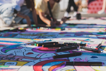 Process of drawing on asphalt and pavement, kids and children with crayons, chalk and markers, teens creating street art on the ground, graffiti and pictures on sideways, street painting festival - obrazy, fototapety, plakaty