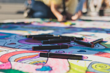 Process of drawing on asphalt and pavement, kids and children with crayons, chalk and markers, teens creating street art on the ground, graffiti and pictures on sideways, street painting festival