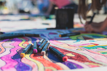 Process of drawing on asphalt and pavement, kids and children with crayons, chalk and markers, teens creating street art on the ground, graffiti and pictures on sideways, street painting festival - obrazy, fototapety, plakaty