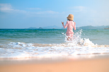 A child girl 6 years old plays on the beach with waves. One preschool-age girl on the seashore