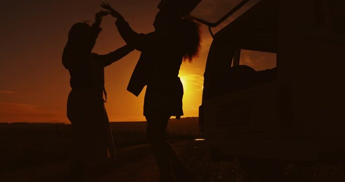 Hive five, silhouette and friends travel with van in at sunset, night or dark together on vacation packing luggage or bags. Hug, love and people greeting for success on a trip, holiday and camping