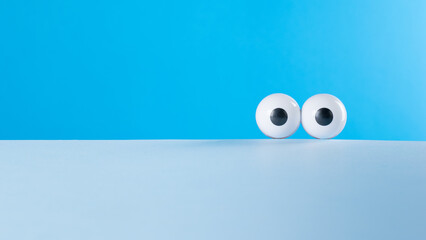 Creative image of the eyes on a two-tone blue background.