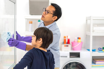 Family asian father and kid little boy son doing household cleaning and washing in protective...