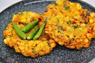 Jakarta, Indonesia - August 29, 2023: Perkedel Jagung or Bakwan Jagung, corn fritters is Indonesian traditional food. Savoury snack made of corn, egg, flour, spring onion, pepper and salt.