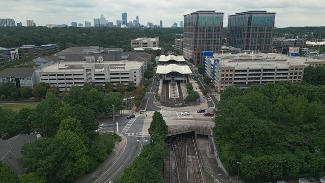 Aerial approaching shot of Lindbergh Marta Station wit Atlanta Downtown in background 