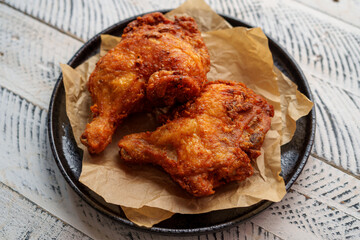 Crispy chicken thighs fried on a wooden table