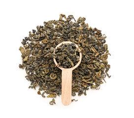 Wooden spoon with dry green tea leaves on white background