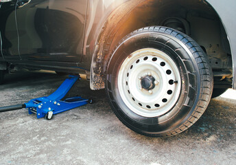 Lifting a pickup truck with a hydraulic floor jack for servicing and maintenance in auto repair...