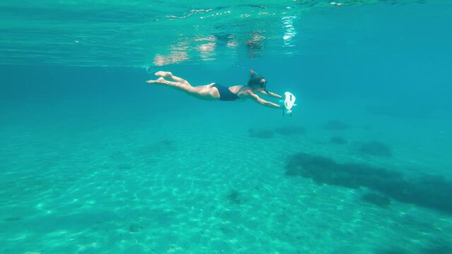 Female using underwater scooter for diving. Modern technology concept.