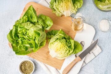 Wooden board with fresh Boston lettuce on white background