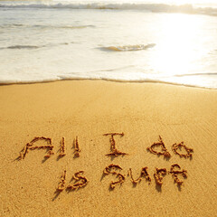 The word all i do is surf written in the sand on the beach