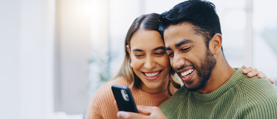 Love, hug and happy couple with phone in a house for social media, streaming or checking meme in their home together. Smartphone, app and people smile in a living room for funny gif, text or chat - obrazy, fototapety, plakaty