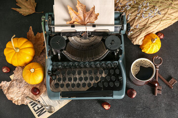 Vintage typewriter, pumpkins, chestnuts, cup of coffee, keys and autumn leaves on black background