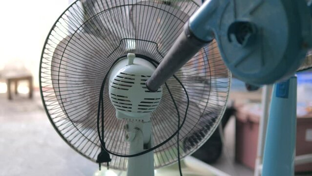 The people use electric bower to cleaning the fan. Dust removing. DIY and home care concept