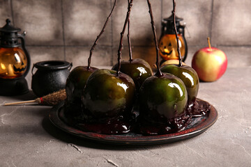 Plate of tasty caramel apples for Halloween on table
