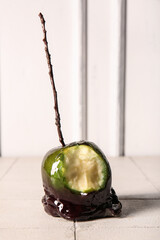 Tasty bitten caramel apple for Halloween on table