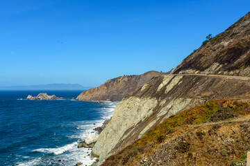 Fototapeta na wymiar Scenic landscape of California coast showcasing the blue ocean, rugged cliffs, and a clear sky near Devils Slide trail