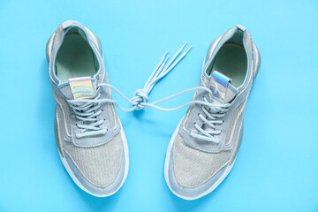 Stylish blue sneakers on color background