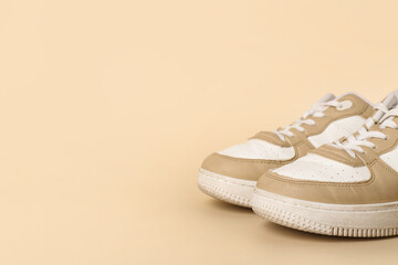 Stylish sneakers on beige background