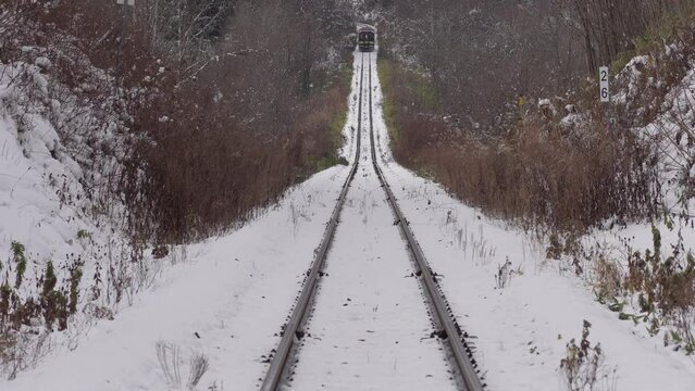 Hokkaido, Japan - November 15, 2023: A train of Furano Line running between Bibaushi station and Biei station in winter, Hokkaido, Japan 

