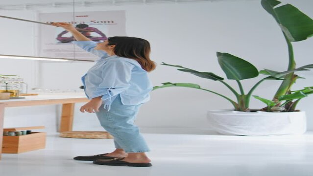 Girl lighting aroma sticks at home. Woman holding santo palo tree vertically
